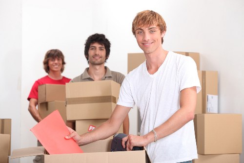 Trained moving staff using PPE and lifting equipment during a house move
